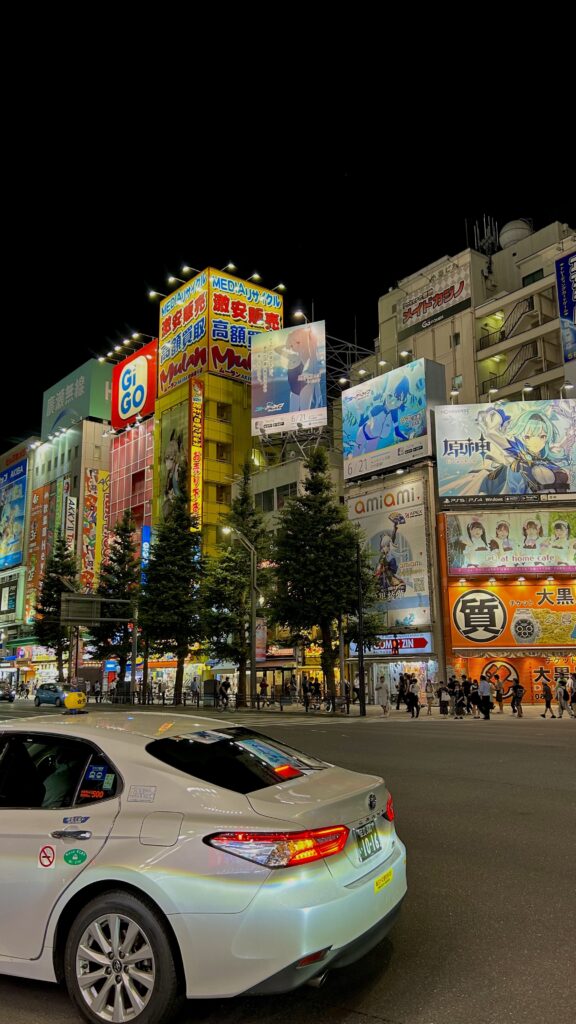 Buildings and taxi lit up at night