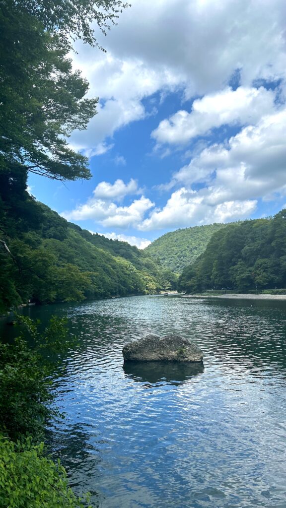 A lake surrounded by green trees and hills