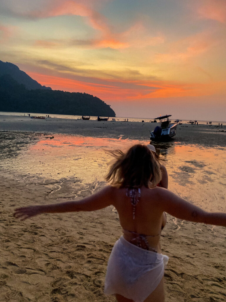 Two girls dancing on a beach at sunset