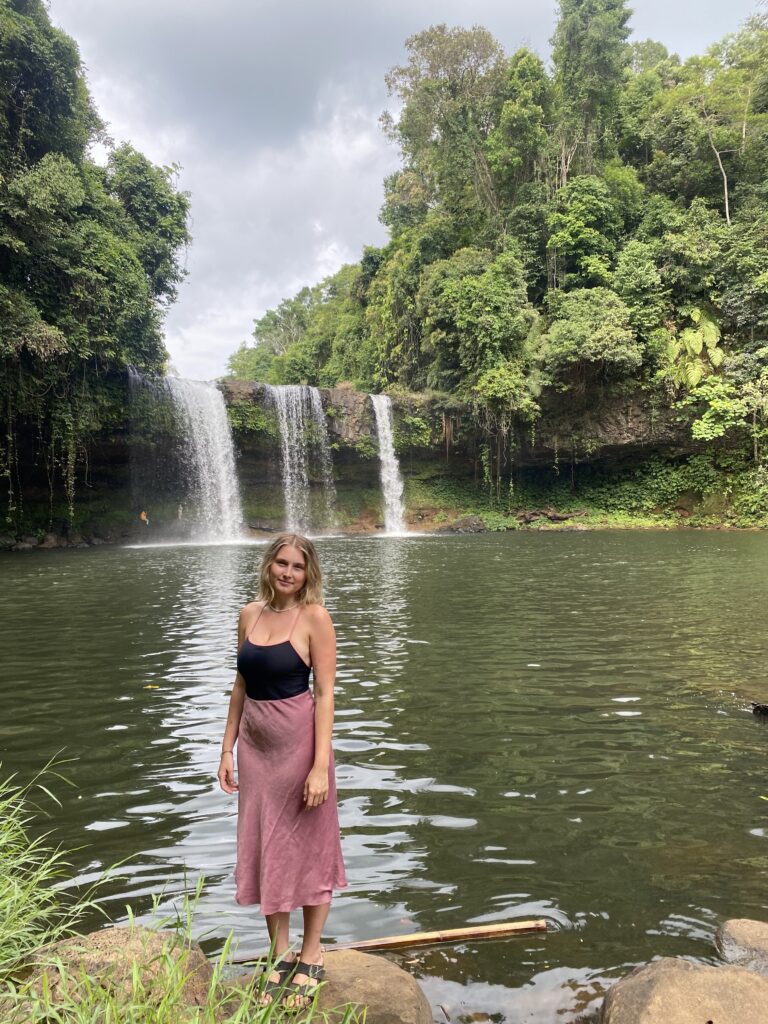 Girl stood in front of waterfall